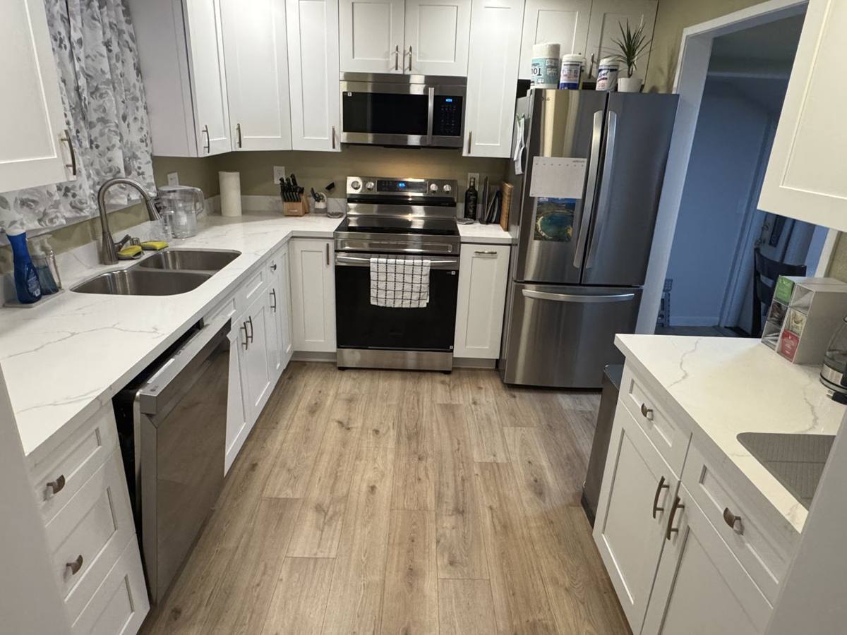 Kitchen with white cabinets, quartz counters and stainless appliances